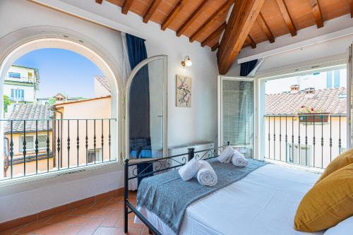 ein Schlafzimmer mit einem Bett und einem großen Fenster in der Unterkunft Palazzo Ghibellina by Rental in Florence in Florenz