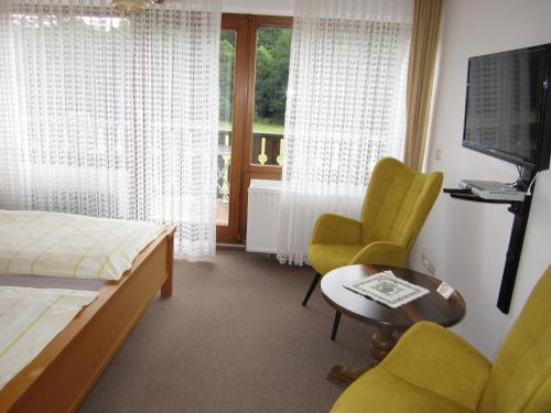 um quarto de hotel com uma cama e duas cadeiras e uma mesa em Pension-Gästehaus Waldhof em Winterberg