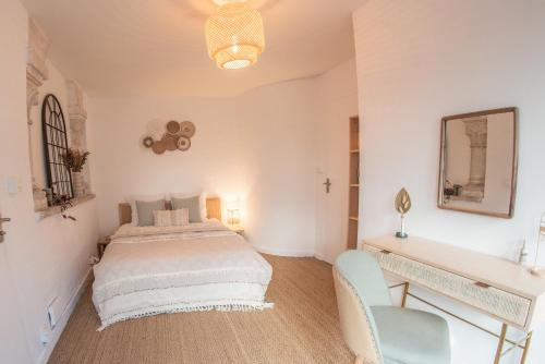 um quarto com uma cama, uma secretária e uma cadeira em Couvent des Cordelières supplément SPA em Vezins