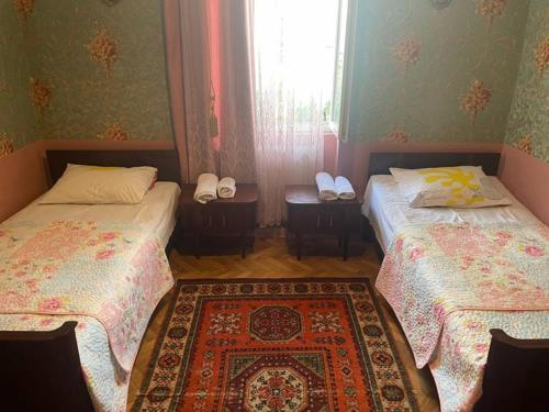a room with two beds and a rug at hotel castle in Kutaisi