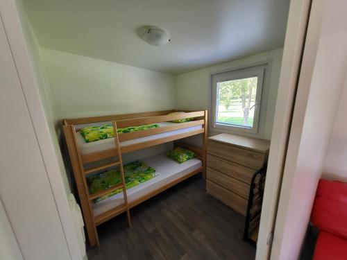 a small room with bunk beds and a window at kamp katra mobilna hiška EXCLUSIVE in Vinica