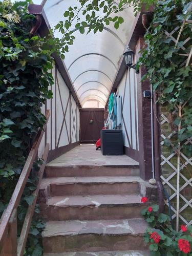 Un pasillo con escaleras y un techo con flores. en COMME UNE MAISON, duplex terrasse hypercentre de Trouville, en Trouville-sur-Mer