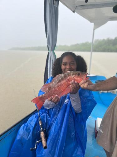 a woman on a boat holding a fish at Cabinas Chazu #2 in Quepos