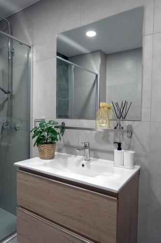 a bathroom with a sink and a shower with a mirror at Paradise Gardens - Golf del Sur in San Miguel de Abona