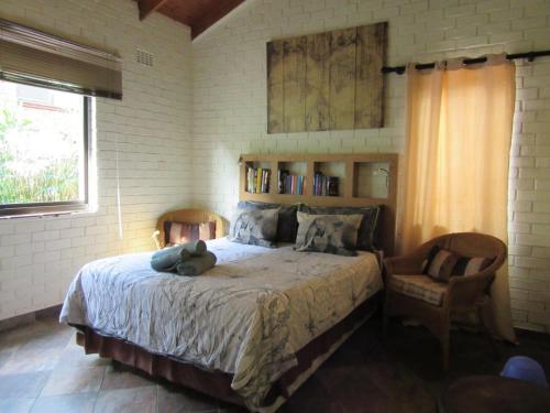 a bedroom with a bed with a teddy bear on it at Manzini Chalet No 34 in St Lucia