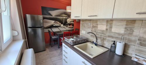 a small kitchen with a sink and a refrigerator at Platán Apartman in Veszprém