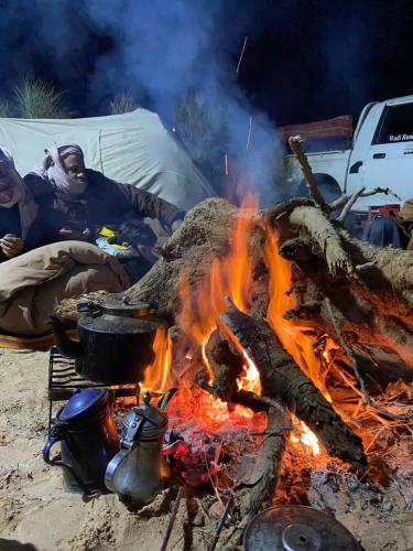 a group of people sitting around a campfire at Bedouin Desert Cave in Wadi Rum