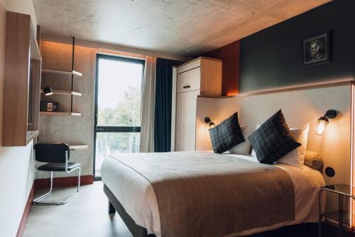 une chambre d'hôtel avec un grand lit et une fenêtre dans l'établissement greet Hotel La Rochelle Centre, à La Rochelle