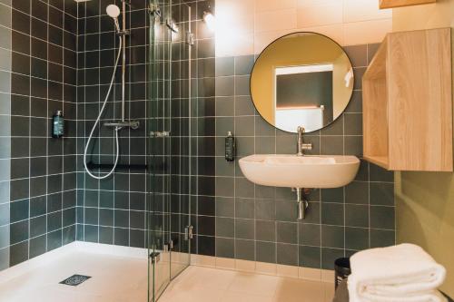 une salle de bain avec un lavabo, une douche et un miroir dans l'établissement greet Hotel La Rochelle Centre, à La Rochelle