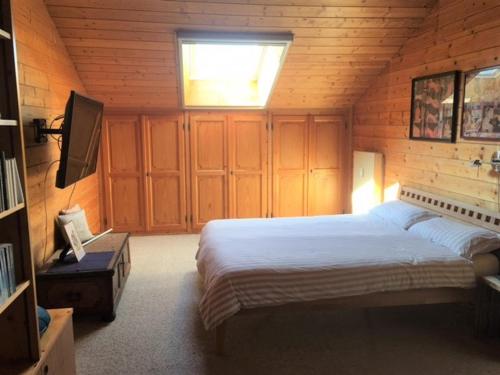 Ferienwohnung Kunze في برين أم كيمزيه: غرفة نوم بسرير كبير في غرفة خشبية