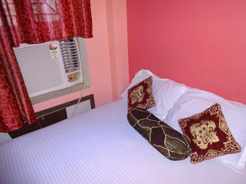 1 dormitorio con 1 cama con 2 almohadas y ventana en Hotel Viraat Inn, en Gaya
