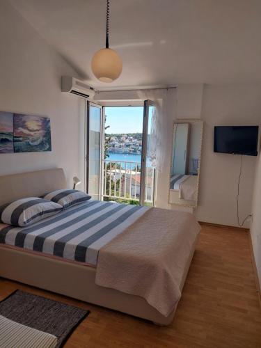 a bedroom with a large bed and a large window at The Look in Mali Lošinj