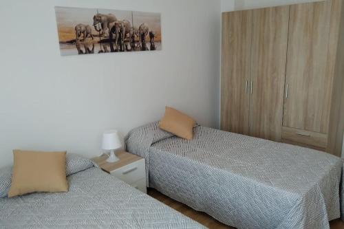 een slaapkamer met 2 bedden en een foto aan de muur bij Ven y desconecta!! in Viana