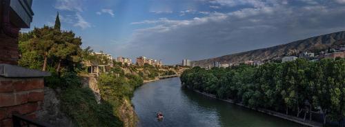 a river with a boat on it in a city at Apartment in the heart of Old Tbilisi in Tbilisi City