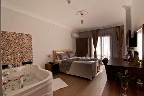 a bathroom with a bed and a tub in a room at DEFNE OTEL in Sile