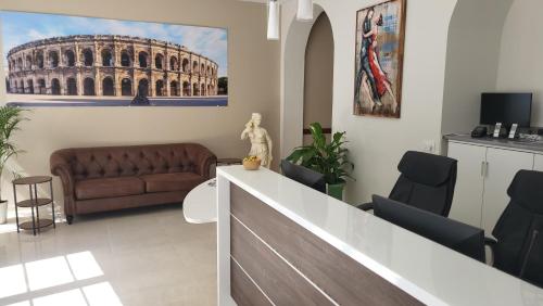 ein Wohnzimmer mit einem Sofa und einem Gemälde des Kolosseums in der Unterkunft SQUARE HOTEL in Nîmes