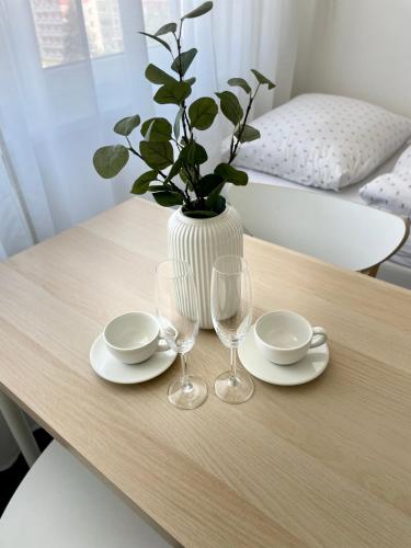 uma mesa com dois copos e um vaso com uma planta em Apartmány Bryksova em Praga