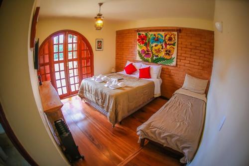 a bedroom with a bed and a window at Mansão Austríaca Guesthouse in Campos do Jordão