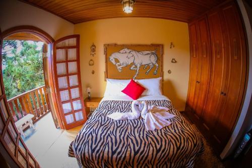 a bedroom with a bed with a zebra head board at Mansão Austríaca Guesthouse in Campos do Jordão
