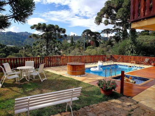 a backyard with a pool with a table and a fountain at Mansão Austríaca Guesthouse in Campos do Jordão