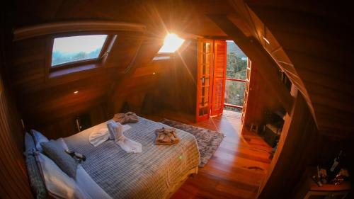 a woman sitting on a bed in a room with a window at Mansão Austríaca Guesthouse in Campos do Jordão