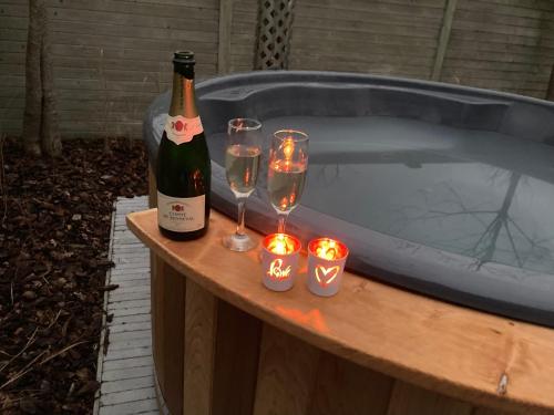 a bottle of wine and glasses on a table next to a tub at De Notelaar in Alveringem