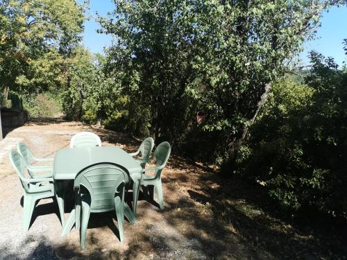 a table and chairs with a table and trees at Appartement dans maison individuelle LE CAYLUS BAS in Saint-Affrique
