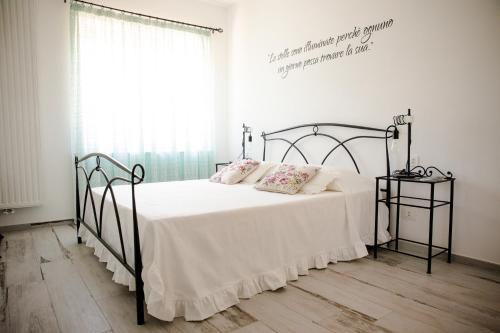 1 dormitorio con 1 cama con sábanas y almohadas blancas en Il Principe rosso, en Roatto