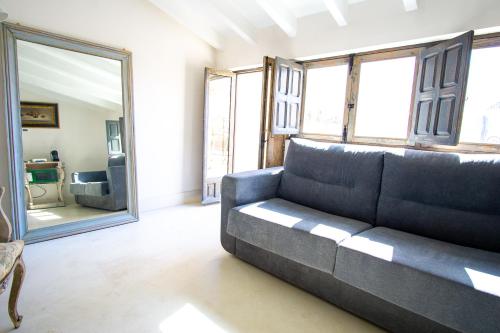 a living room with a couch and a mirror at Apartamentos Sharis in Jerez de la Frontera