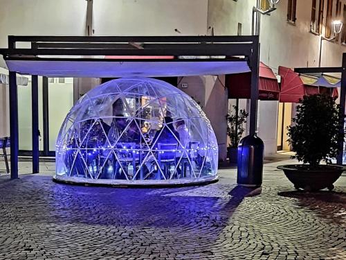 a large igloo sitting on the street with blue lights at Vinoteca La Sacrestia in Alba