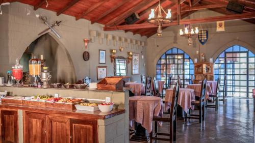 a restaurant with tables and chairs in a building at Pousada Camelot Inn in Alto Paraíso de Goiás