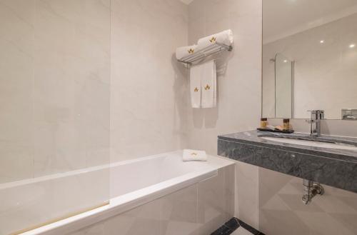 a white bathroom with a tub and a sink at Lagoa Hotel in Lagoa