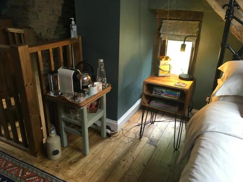 a bedroom with a bed and a table with a microwave at The Hideaway in Ripponden