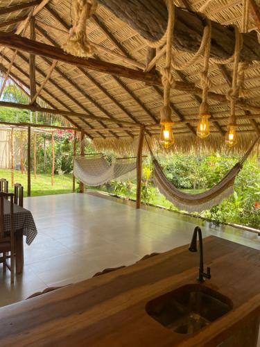 a room with a hammock and a table and a sink at Vila Ypáwa 150 m centro 30 m praia lago verde in Alter do Chao