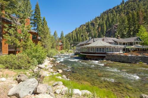 a building next to a river next to a mountain at Granite River Retreat at Alpine Meadows in Alpine Meadows