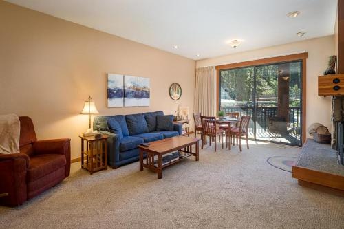 a living room with a blue couch and a table at Granite River Retreat at Alpine Meadows in Alpine Meadows