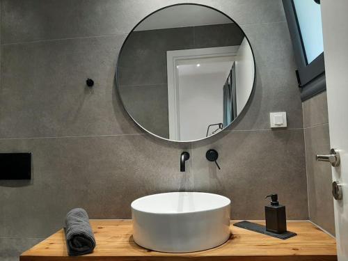 a bathroom with a white sink and a mirror at FSM APARTMENTS PERDIKA 2 in Perdika