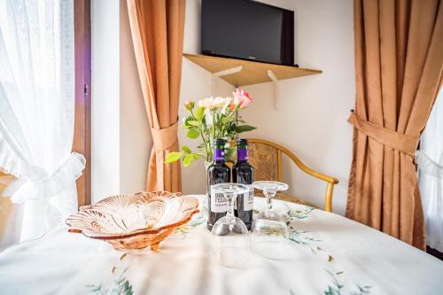 a table with a vase of flowers and wine bottles at Landhaus Weiß in Bad Reichenhall