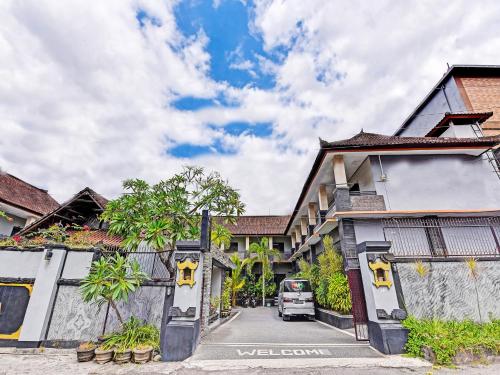 a van parked on a street next to buildings at Hotel Diana 1 in Denpasar