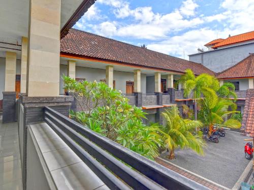 a balcony of a building with trees and plants at Hotel Diana 1 in Denpasar