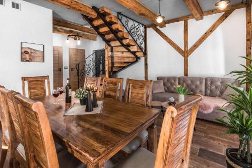 - une salle à manger avec une table en bois et un canapé dans l'établissement Domki nad potokiem, à Muszynka