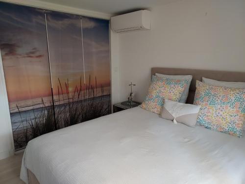 a bedroom with a white bed with pillows and a window at Rez-de-chaussée privatif spacieux 3* d'une villa centre ville in Hyères