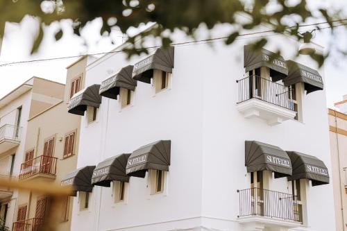 un edificio blanco con balcones negros. en Suite1212 - Bandiera en Monopoli