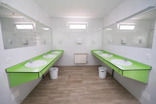 La salle de bains est pourvue de 3 lavabos et de 2 miroirs. dans l'établissement Kampaoh Ruiloba, à Liandres