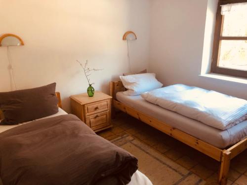 a bedroom with two beds and a nightstand and a window at Fischerhaus in Burgthann