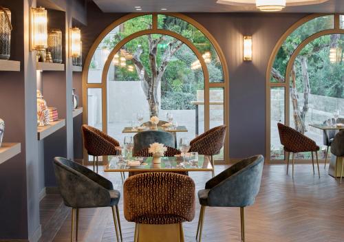 a dining room with a table and chairs and a fireplace at MarBella, Mar-Bella Collection in Agios Ioannis Peristeron