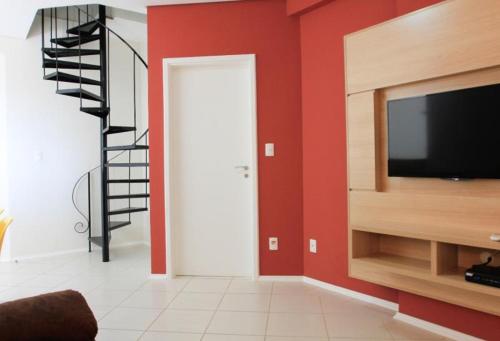 a living room with a television and a staircase at The World Indaiatuba in Indaiatuba