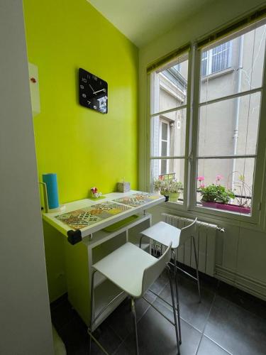 une chambre verte avec un bureau et deux chaises dans l'établissement We Loft, à Paris