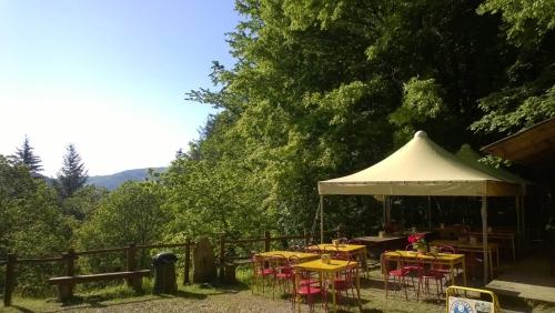 a group of tables and chairs under a white umbrella at Camping Camaldoli in Camaldoli