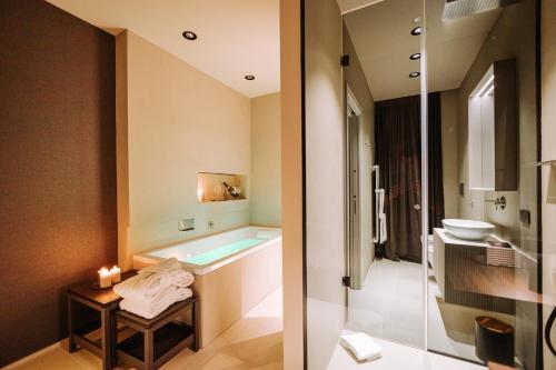 two images of a bathroom with a tub and a sink at Suite1212 - Bandiera in Monopoli